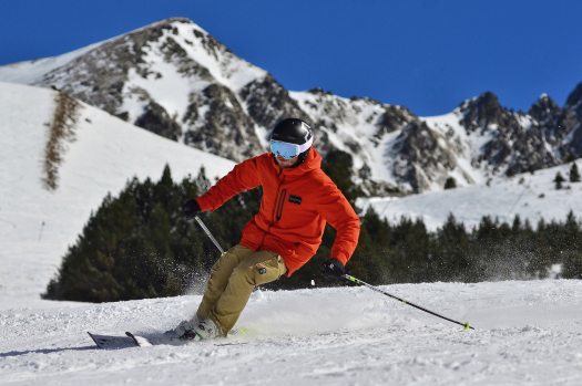 photo-of-a-man-in-an-orange-jacket-and-beige-trousers-skiing-3600571
